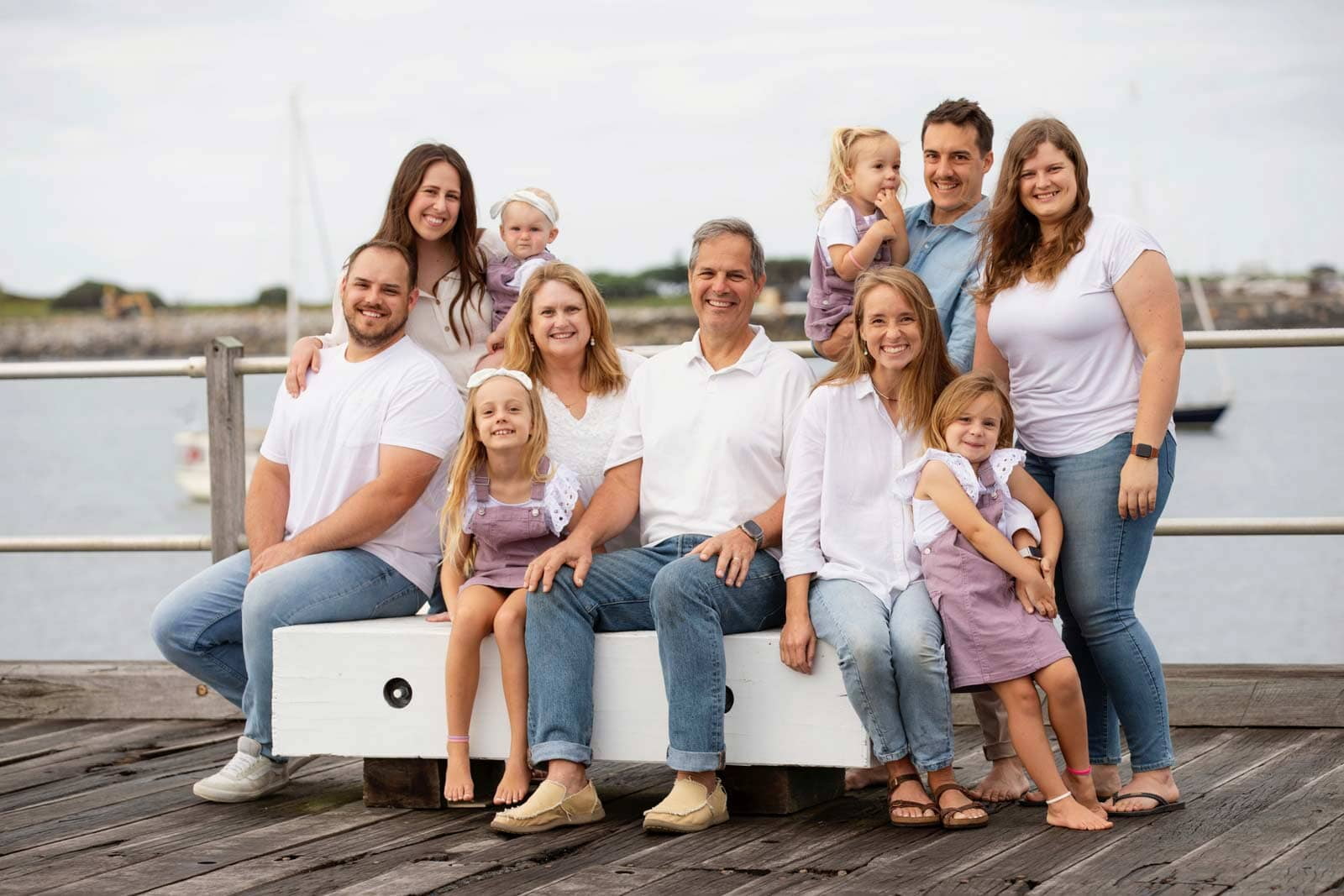 Image of Debbie's family, seated on a timber jetty Image of Debbie's family, seated on a timber jetty