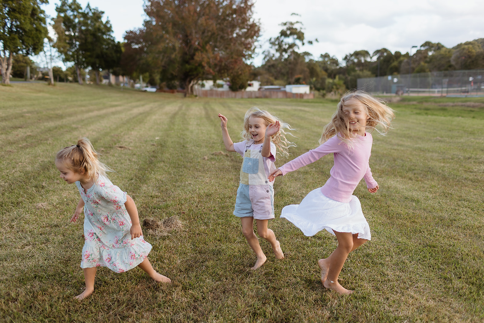 Three girls dancing freely in the park