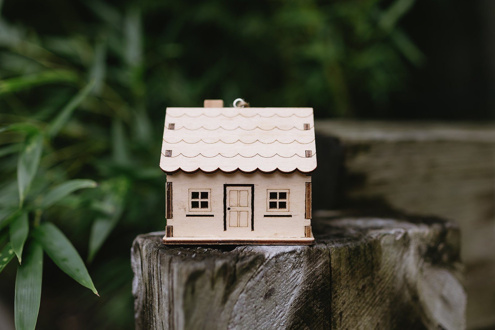 Balsa wood house ornament with garden background