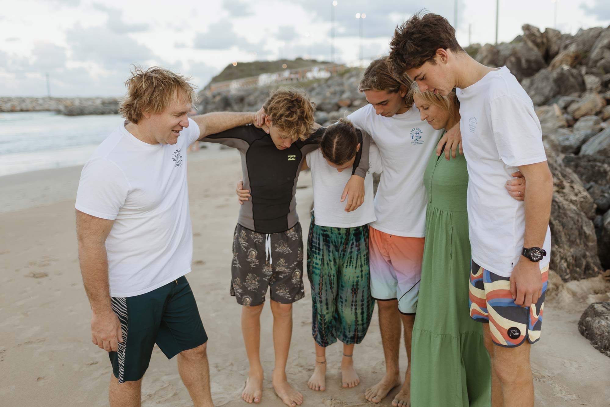 Family with teenage kids praying together on beach Family with teenage kids praying together on beach